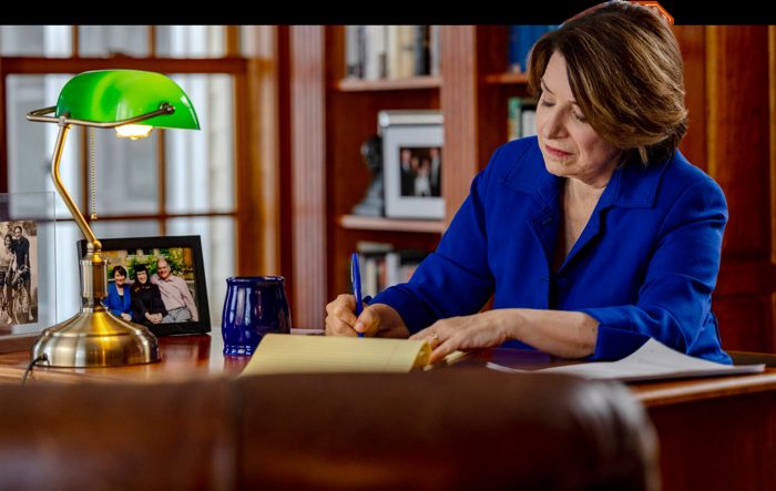 Amy Klobuchar working at a desk — photograph from her campaign homepage