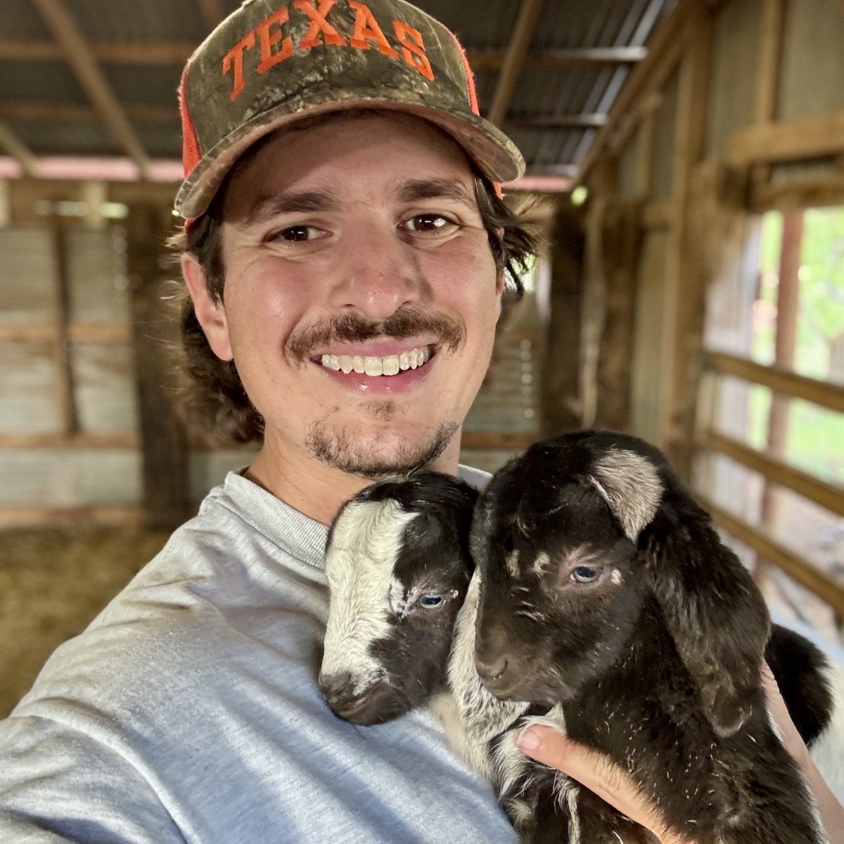 Clayton Tucker holding a young goat — photograph identified on his campaign website
