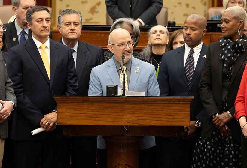 Jon Rosenthal speaking at a lectern — photograph from his campaign website