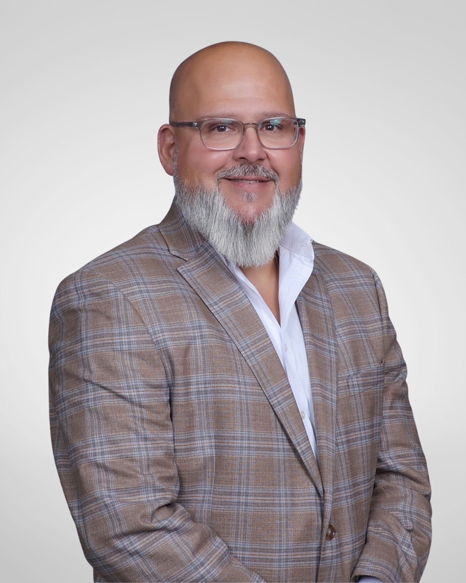 Kason Huddleston in glasses and a checked blazer in his campaign headshot